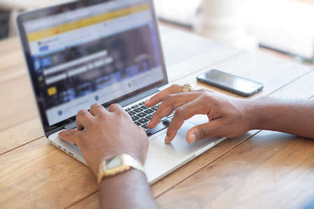Freelancer using modern laptop at wooden desk.の写真素材