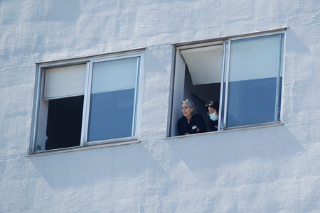 Healthcare workers dealing with the new coronavirus crisis look through the windows of the University Hospital in Coruna, northwestern Spain, on March 26, 2020のeditorial素材
