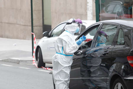 A Coruna-Spain -August 18, 2020: A health worker uses a PCR test (mouth and nasal swab) on a person inside a car to determine the presence or absence of the Covid-19.のeditorial素材