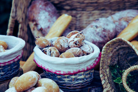 Bread rolls with flour in wicker basketの写真素材