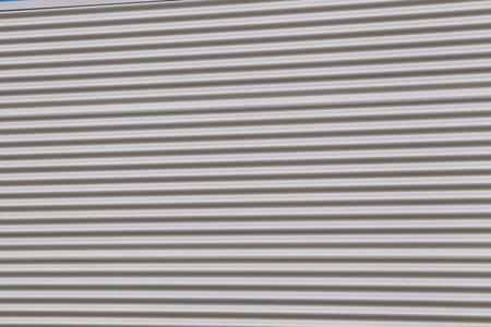 Wide shot of silver corrugated metal with bolts