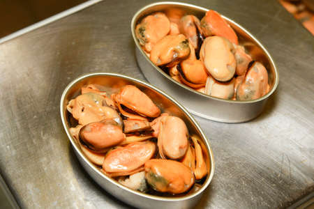 mussels inside a can on metal plateの写真素材