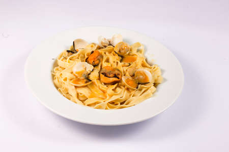 noodle dish with mussels and clams on white backgroundの写真素材