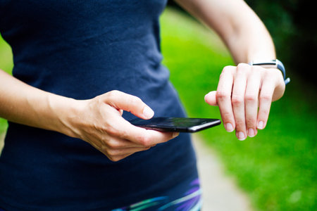 female athlete using fitness app on her smart watch to monitor workout performance. Web banner.