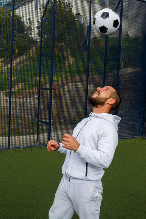 Young male soccer player juggles a ball on a soccer fieldの写真素材
