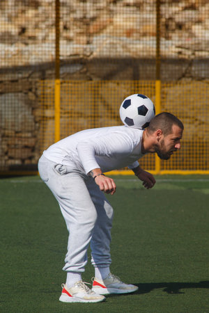 Young male soccer player juggles a ball on a soccer fieldの写真素材