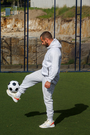 Young male soccer player juggles a ball on a soccer fieldの写真素材