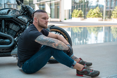 Handsome motorcyclist on his moto riding in the city. high quality photo