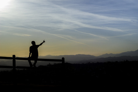 Person silhouette pointing finger to skyの写真素材