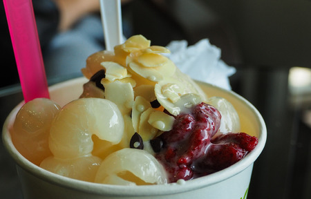 Icecream yogurt topped with fruit such as logan, strawberry and almond slice.の写真素材