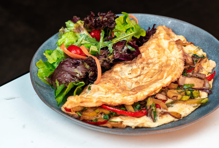 Stuffed Vegetable Omelette with Mixed Leaf Salad. Bright cherry tomatoes and colorful peppers....