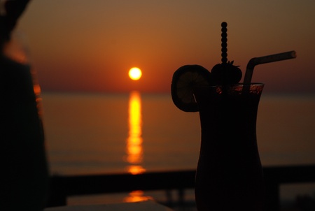Drinking cocktail on sunsetの写真素材