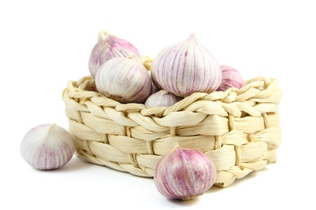 Chinese garlic in a wicker basket  isolated over whiteの写真素材