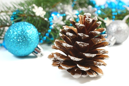 Christmas composition with pinecone and blue ball over whiteの写真素材