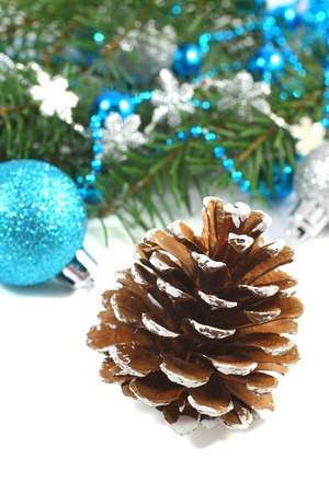 Christmas composition with pinecone and blue ball over whiteの写真素材