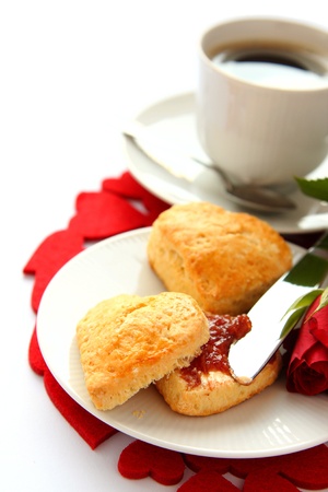 Heart shaped scones with strawberry jam and a cup of teaの写真素材