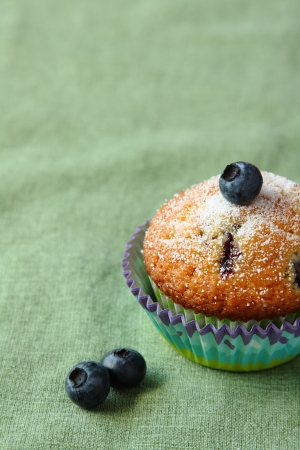 Homemade blueberry muffin with fresh blueberries on green backgroundの写真素材