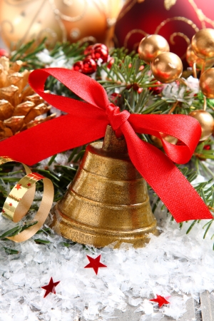 Golden bell with red satin ribbon bow and christmas decorationの写真素材