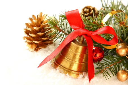 Golden bell with red satin ribbon bow and christmas decoration over whiteの写真素材
