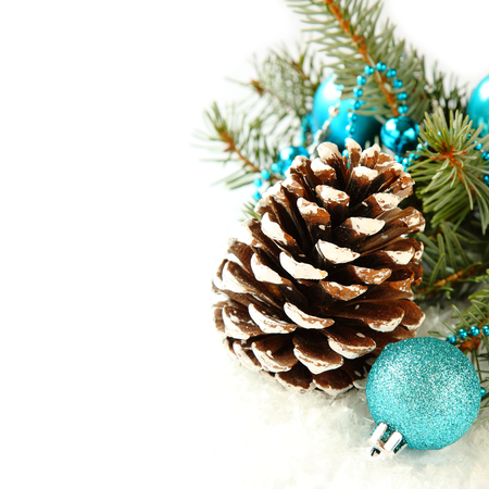 Pinecone with christmas decoration and blue ball over whiteの写真素材