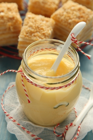 Custard cream in glass jar with white ceramic spoonの写真素材