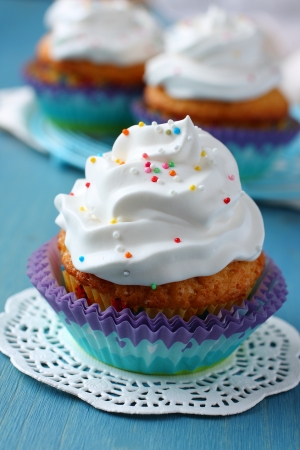 Cupcakes with white cream icing on blue wooden backgroundの写真素材