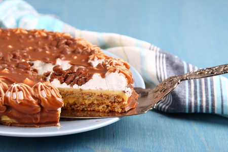 Almond cake with chocolate and cream on blue backgroundの写真素材