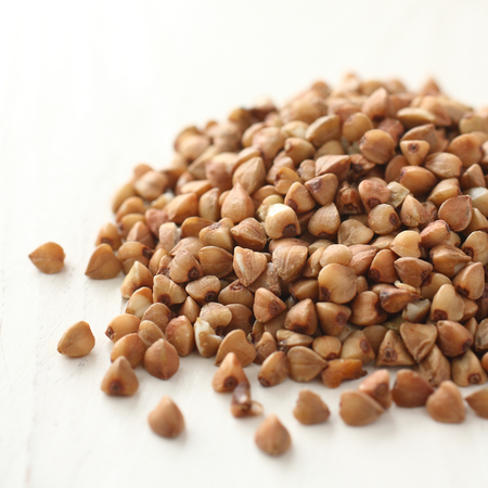 Pile of buckwheat grain on white wooden backgroundの写真素材