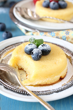 Lemon delicious pudding cake served with berries on plateの写真素材