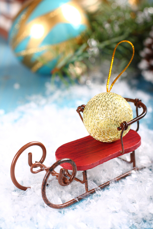 Christmas composition with sleigh and ball on snowの写真素材