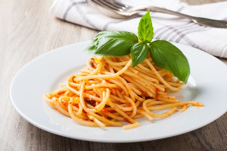 Spaghetti al pomodoro, one of the simplest Italian rustic dishes with the pasta tossed in a sauce of tomato, basil, garlic and a little sugar and oil.の写真素材