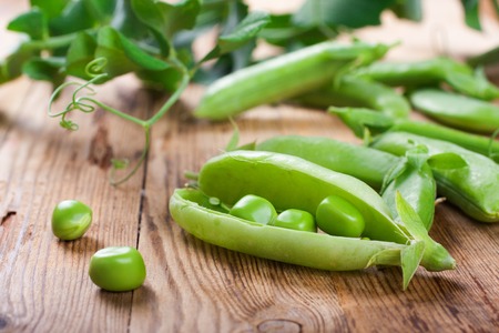 Fresh green peas on old wooden background. Selective focus. Healthy food concept.の写真素材
