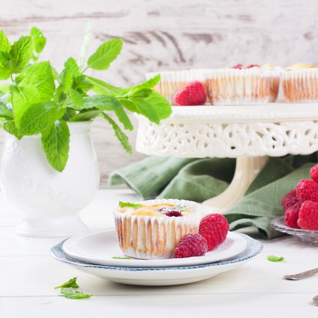 Ricotta mini cheesecake with fresh raspberries and mint leaves, baked in muffin forms. Selective focus. Healthy food concept.の写真素材