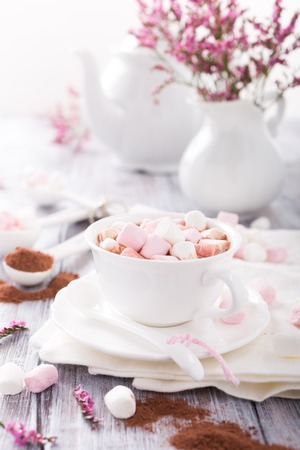 Hot chocolate with mini marshmallows with cocoa on white wooden background.の写真素材