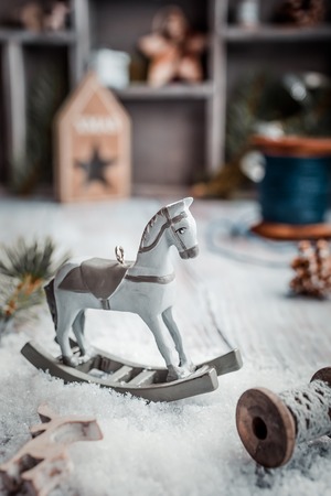 Christmas composition with wooden toy rocking horse and decoration. Christmas greeting card. Retro style toned.の写真素材