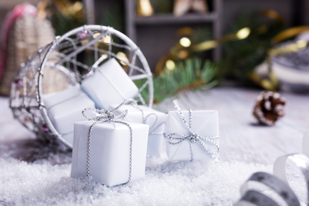 Christmas greeting card with gifts, decorations and snow on wooden white backround.の写真素材