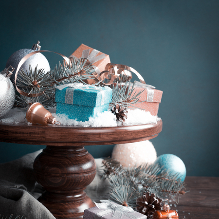 Gifts with christmas decoration on wooden cake stand. Retro style toned christmas greeting card. With copy space for text.の写真素材