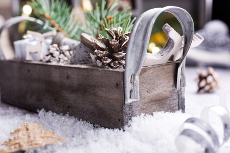 Christmas composition with wooden box with pinecone, gifts and decoration on snow. Christmas greeting card with copy space.の写真素材