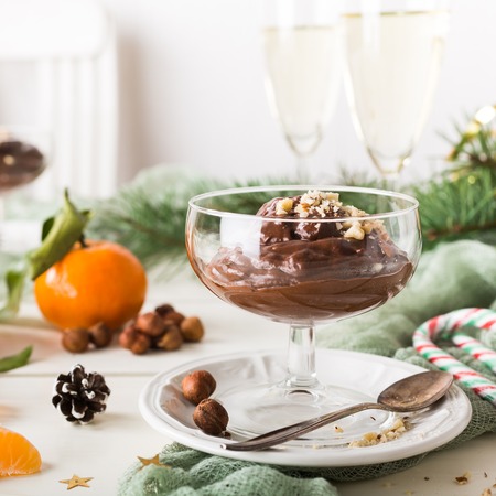 Chocolate pudding mousse with avocado, nuts and christmas decorations. Delicious Christmas themed dinner table.の写真素材