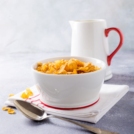 Corn flakes with milk on light gray background. Copy space. Healthy breakfast concept.