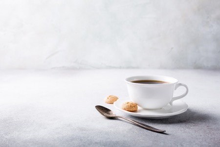 White cup of coffee with amaretti cookies on light gray background with copy space.の写真素材