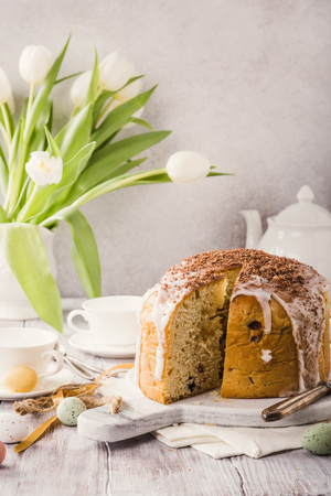 Sliced easter orthodox sweet bread, kulich with white tulips. Retro style toned. Breakfast.の写真素材