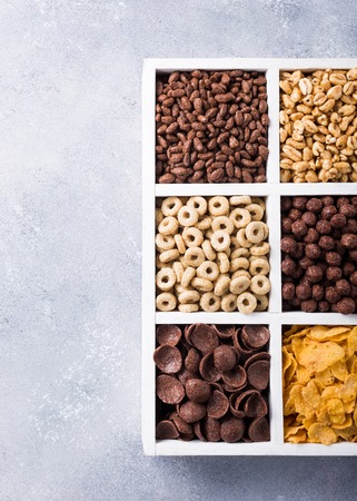 Variety of cold quick breakfast cereals in white wooden box, healthy eating concept with copy space. Top view.の写真素材
