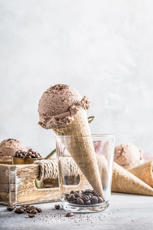 Waffle cone with coffee ice cream in glass and ingredients in wooden tray. Retro style toned photo with copy space.の写真素材