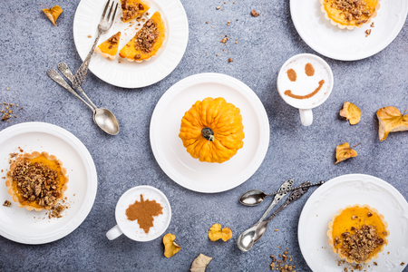Thanksgiving day concept with homemade pumpkin tartlet, mini pie, on gray stone background. Healthy autumn food flat lay, top view.の写真素材