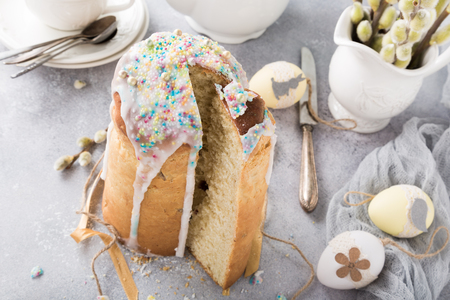 Easter composition with orthodox sliced sweet bread, kulich and eggs on light background. Holidays breakfast.の写真素材