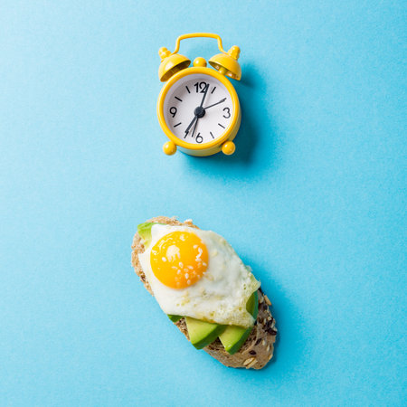 Healthy sandwich with fresh avocado and fried quail eggs