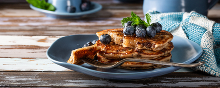 Delicious pancakes with chocolate drops, honey and blueberries. Healthy breakfast concept with copy space. Banner.の写真素材