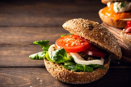Italian Caprese sandwiches with fresh tomatoes, mozzarella cheese and lamb's lettuce, multigrain bun. Healthy food concept with copy spaceの写真素材