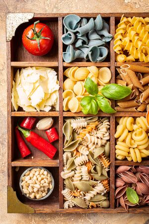 Assorted colorful italian pasta in wooden boxの写真素材